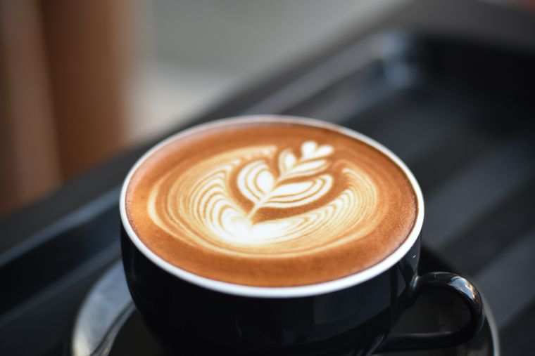 Black coffee in a white cup — caffeine boosts metabolism by up to 11% and mobilizes stored fat