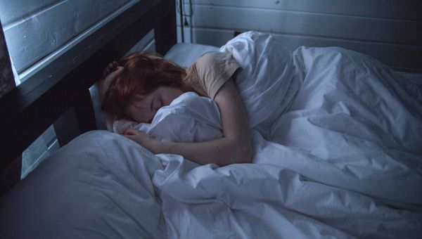 Person sleeping peacefully in dark room — 7 to 9 hours quality sleep protects brain health